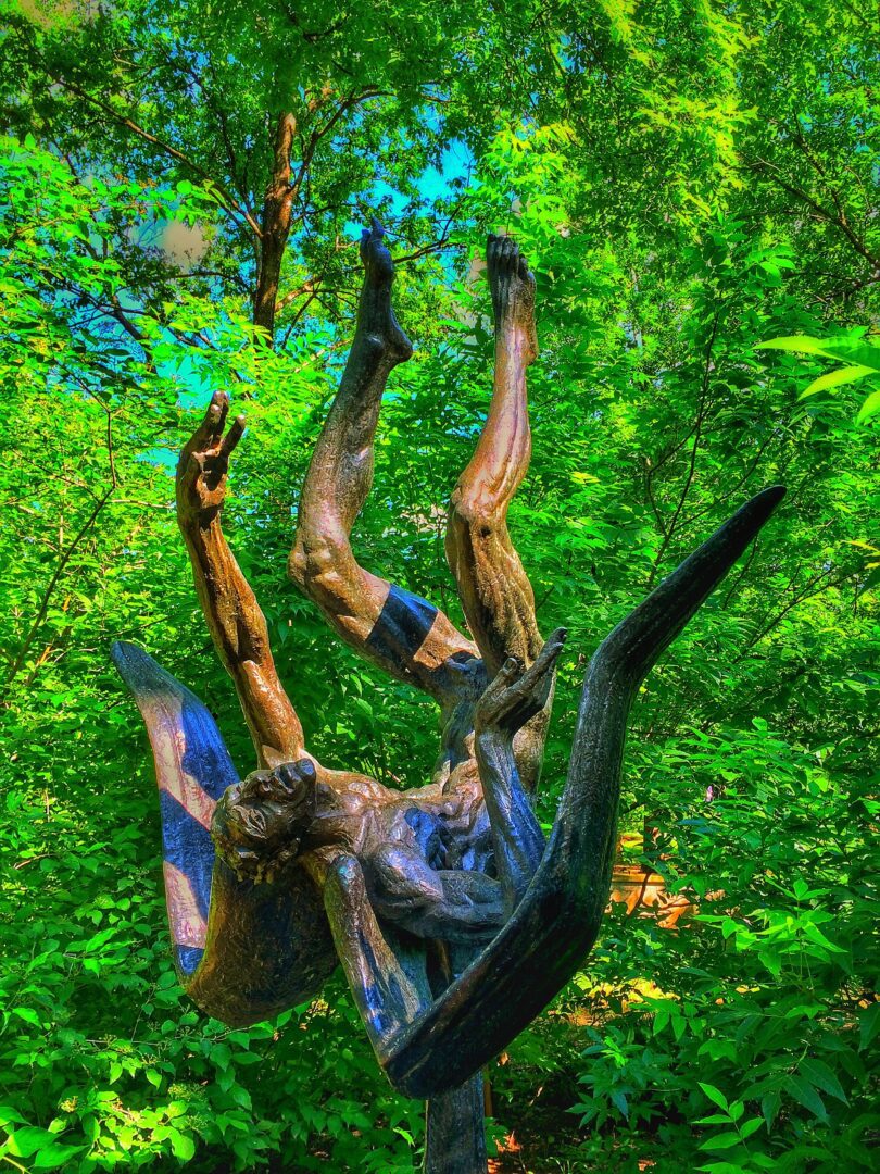 A statue of a man in the woods.