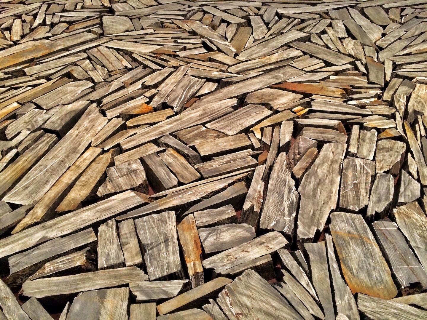 A pile of wooden planks on the ground.