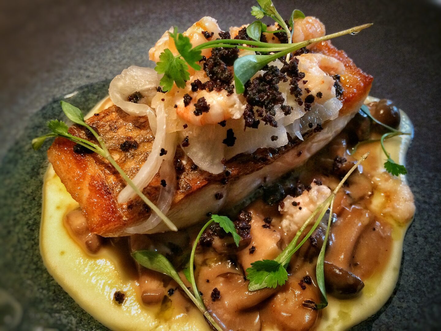 A plate of fish and mushrooms on a plate.