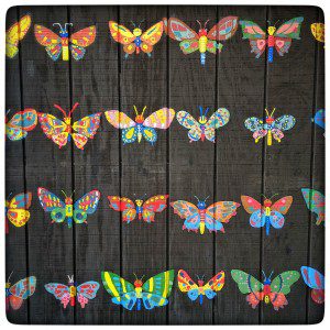 Colorful butterflies painted on a wooden fence.