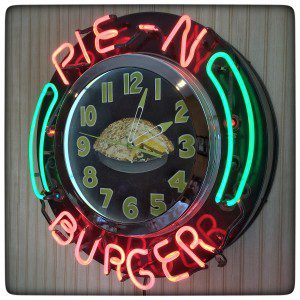 A clock with a pie n burger on it.