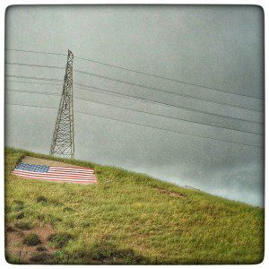 An american flag on a grassy hill.