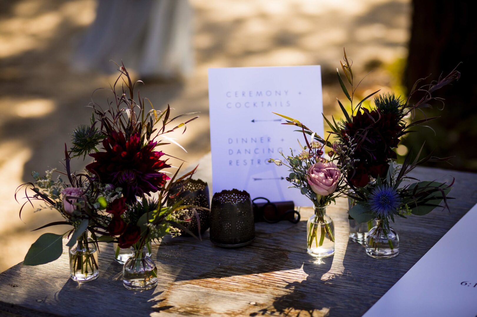 A table with flowers and a sign on it.