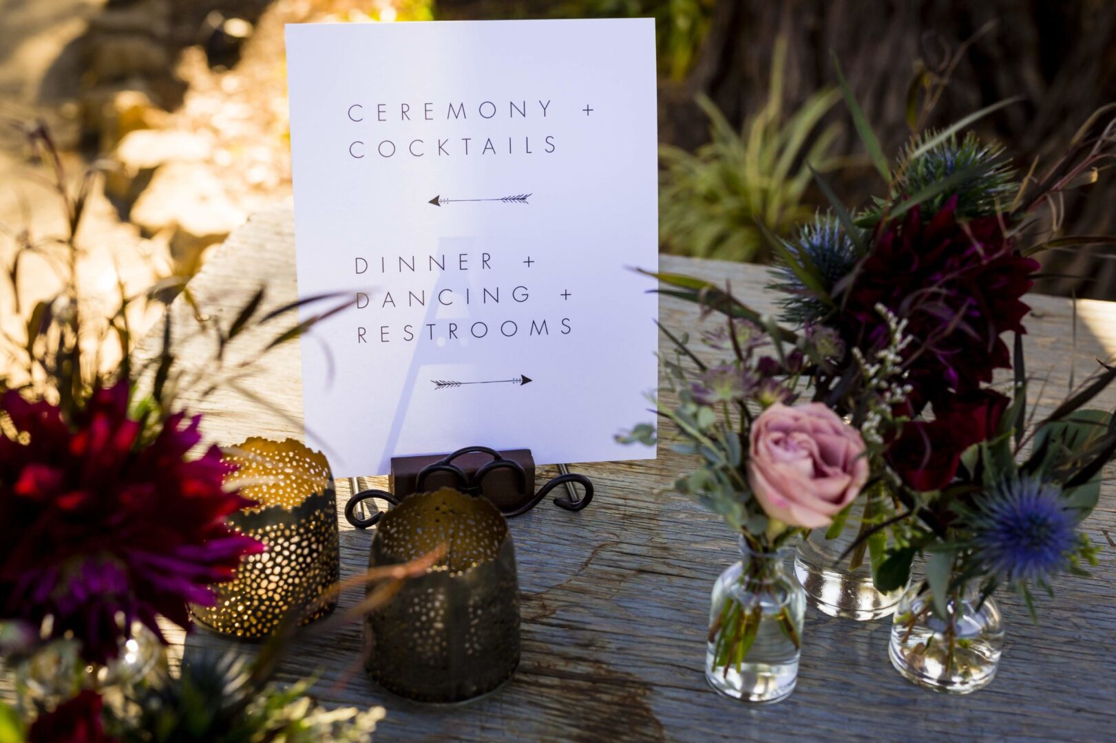 A table with flowers and a sign on it.