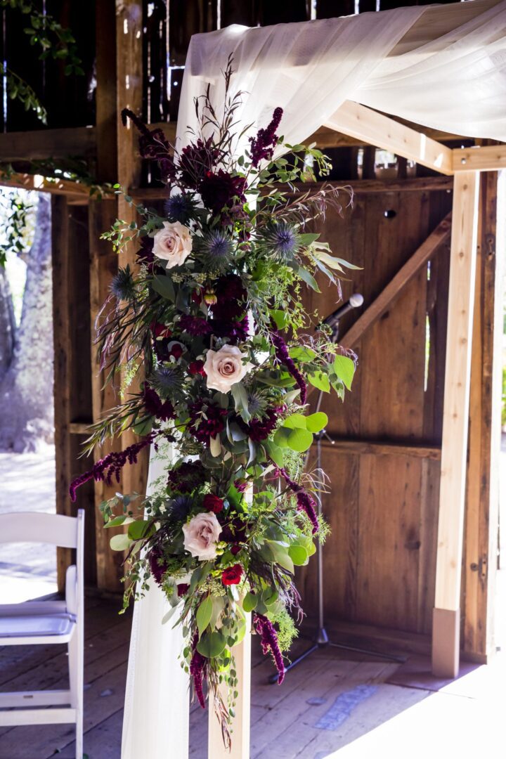 A wedding ceremony in a barn with flowers.