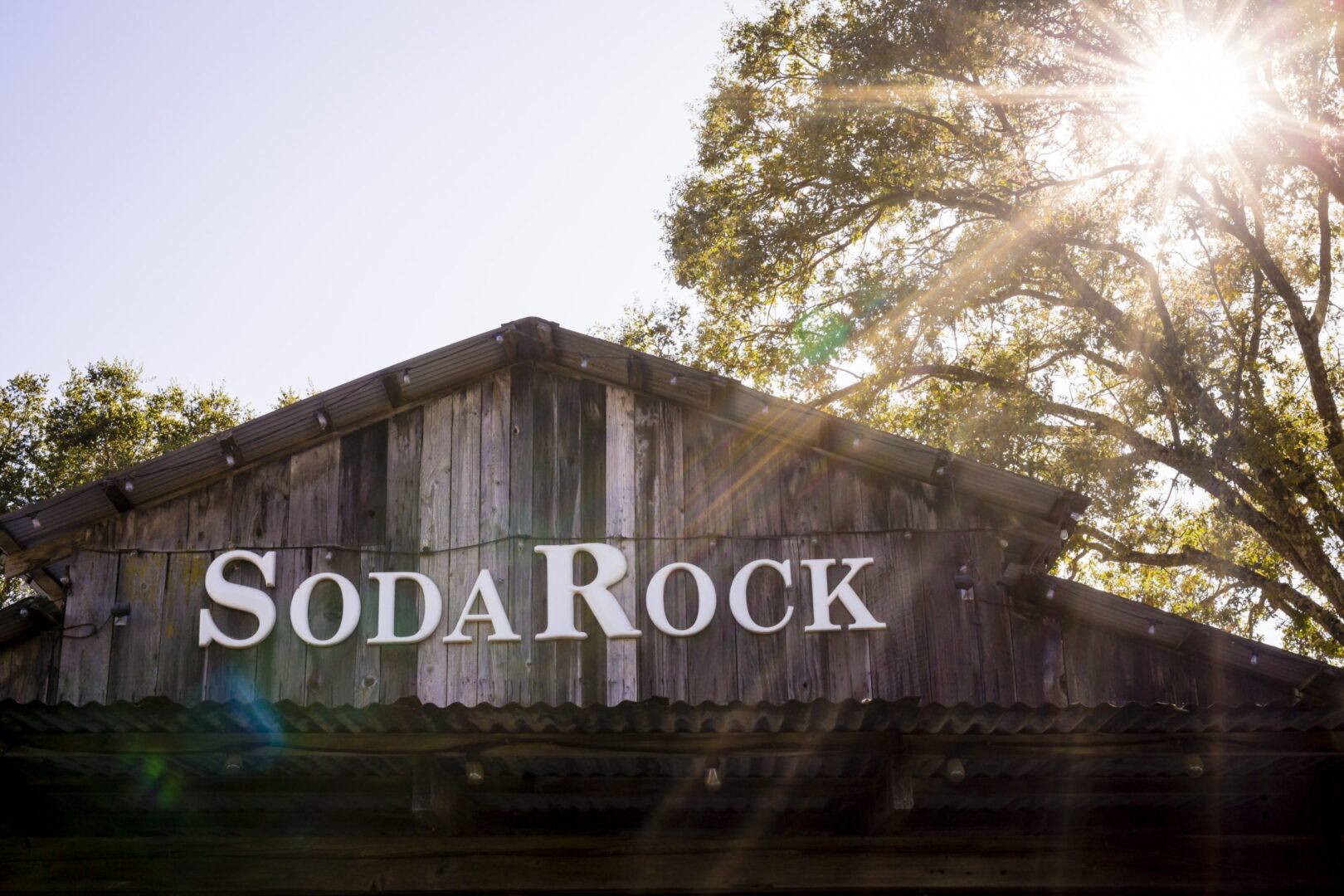 A sign that says soda rock on a wooden building.