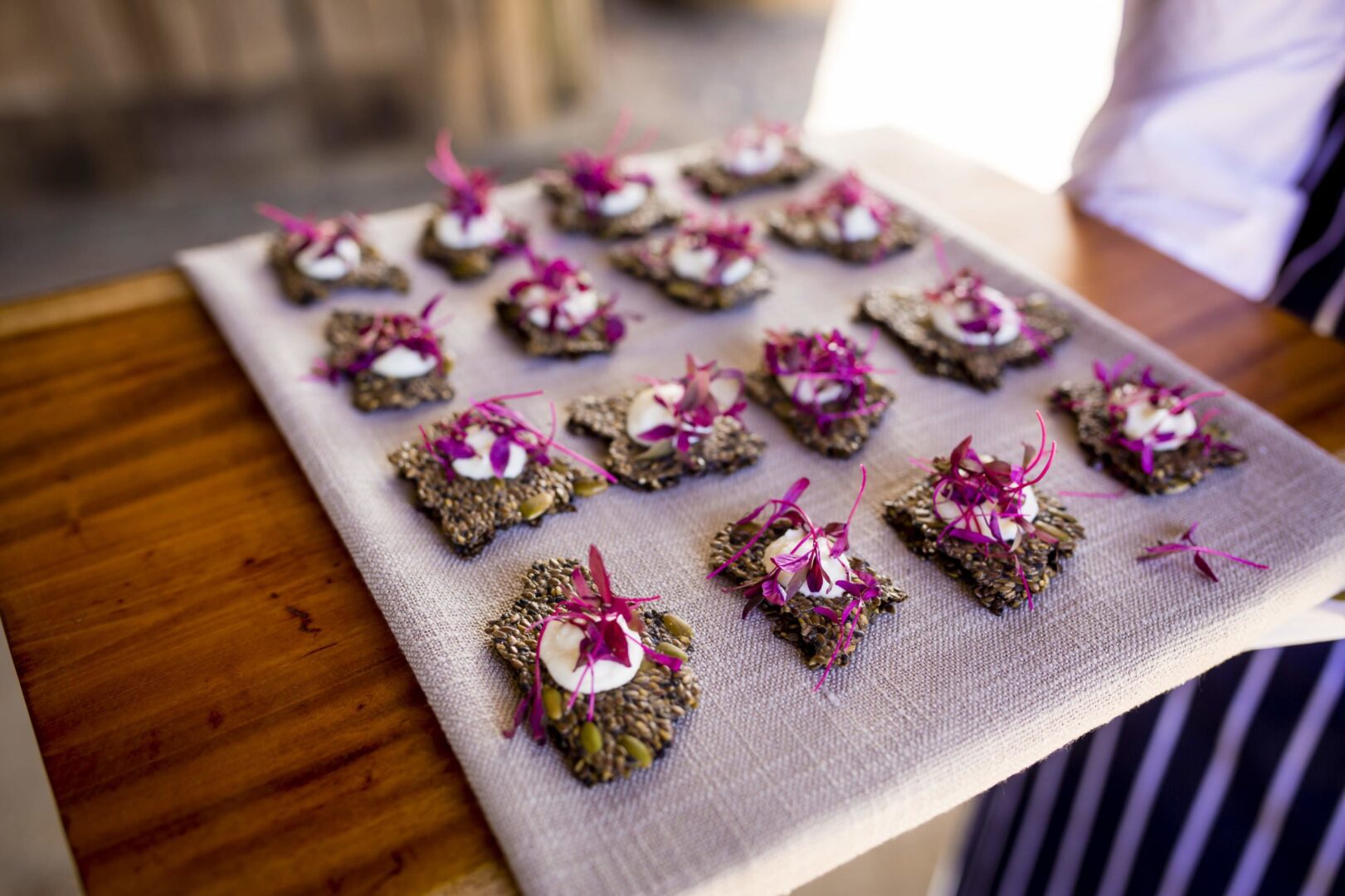 A tray of appetizers with purple flowers on it.