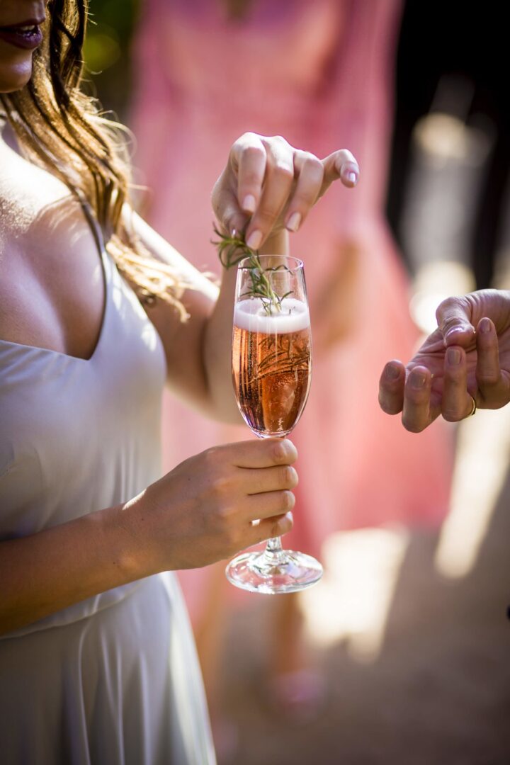 A woman is pouring a glass of champagne to another person.