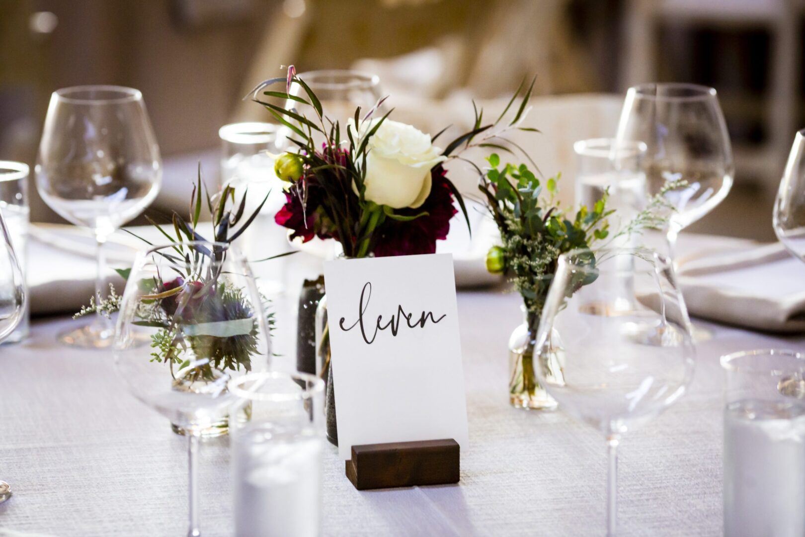 A table setting with wine glasses and flowers.