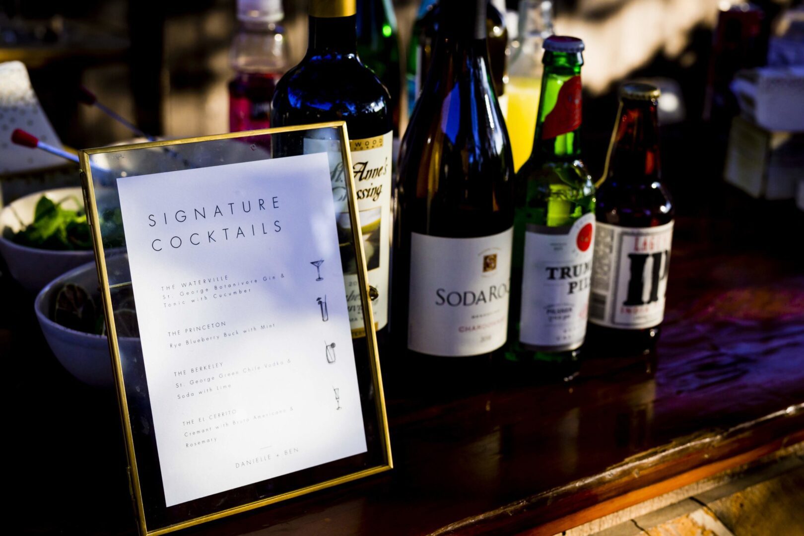 A bottle of wine and a bottle of liquor on a table.