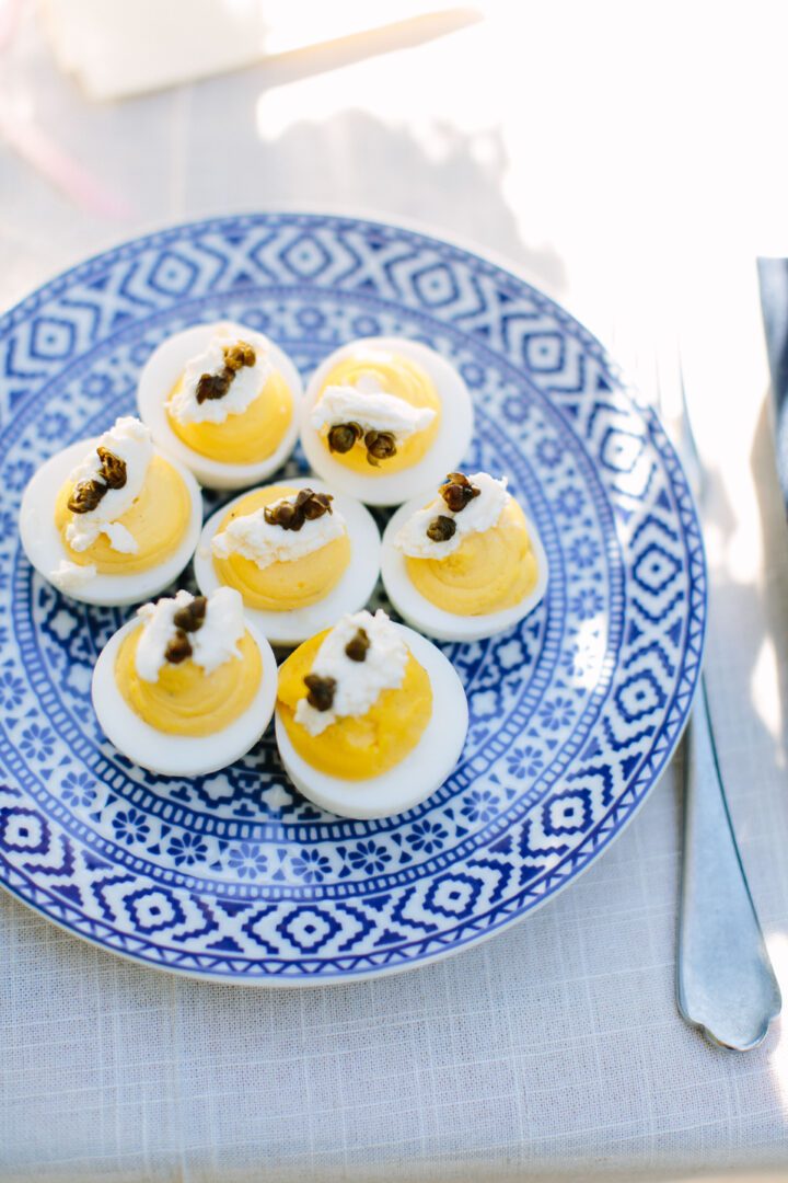 Deviled eggs on a blue and white plate.