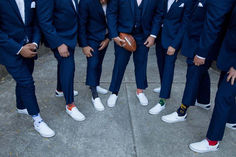 A group of groomsmen wearing blue suits and socks.