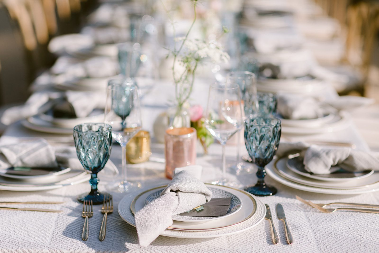 A table setting with blue and white plates and silverware.