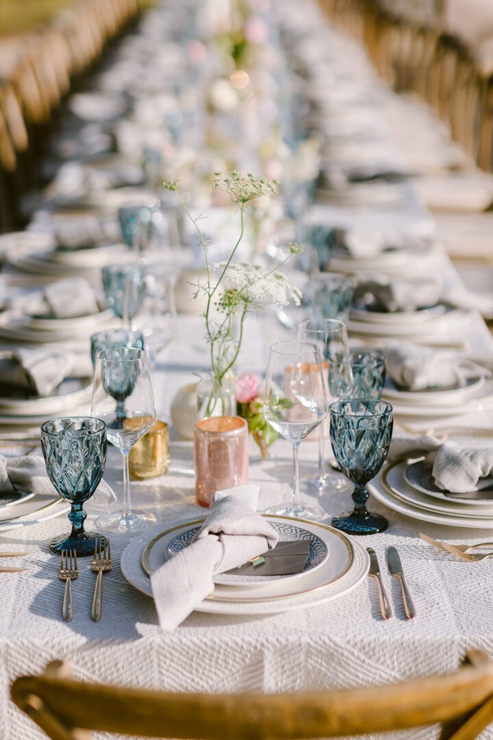 A long table set with blue and white plates and silverware.
