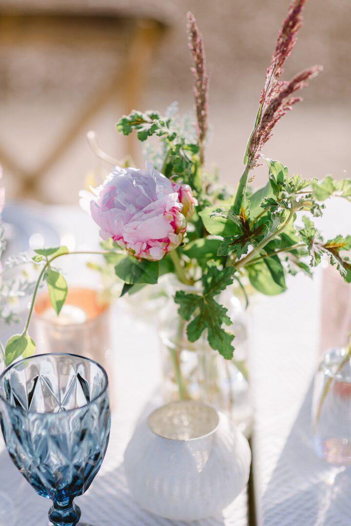 A table setting with vases and flowers on it.