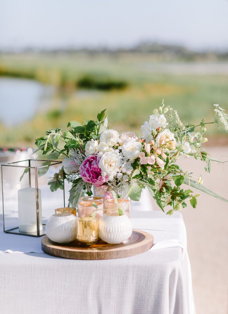 A table with flowers and jars on it.