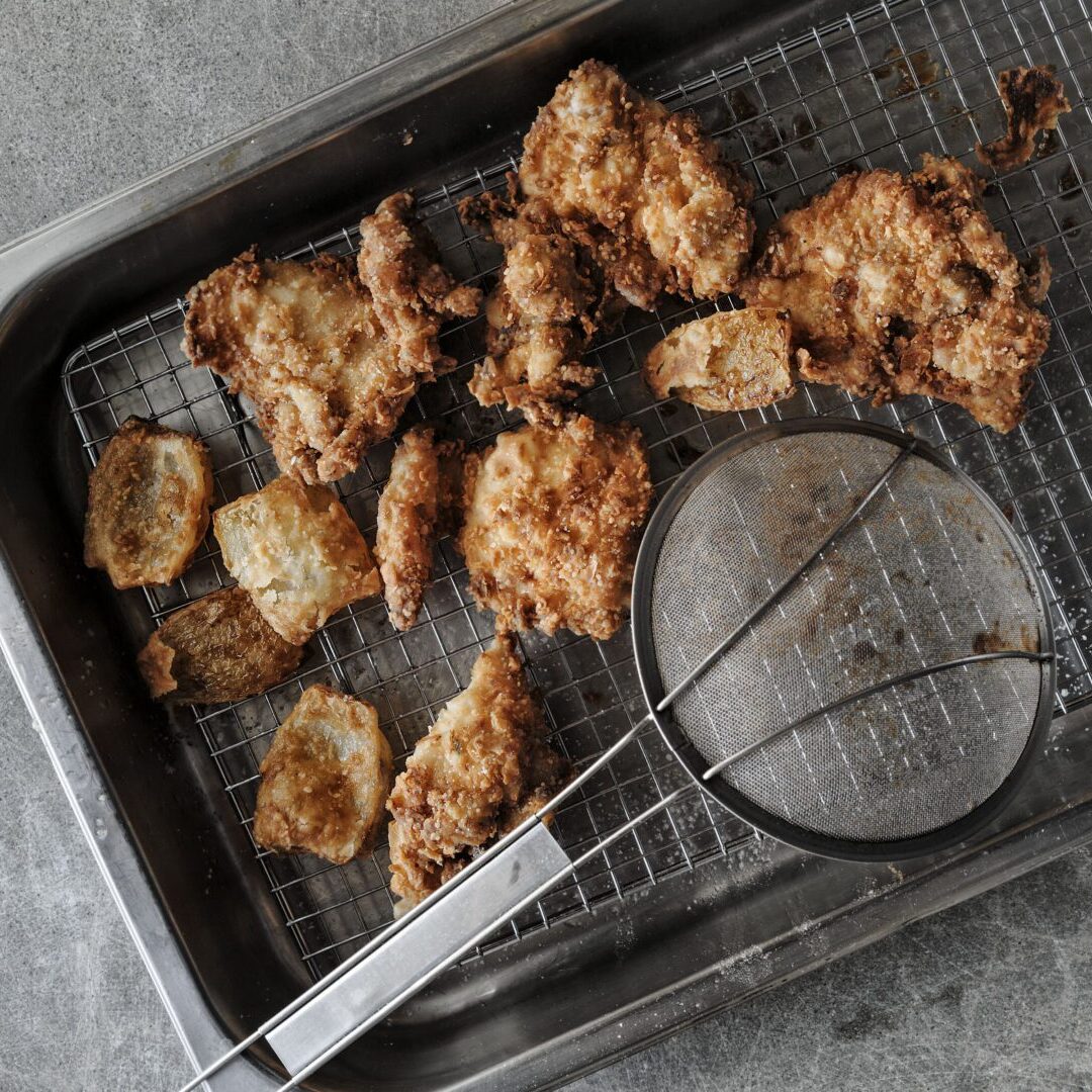 Fried chicken on a tray with a spatula.