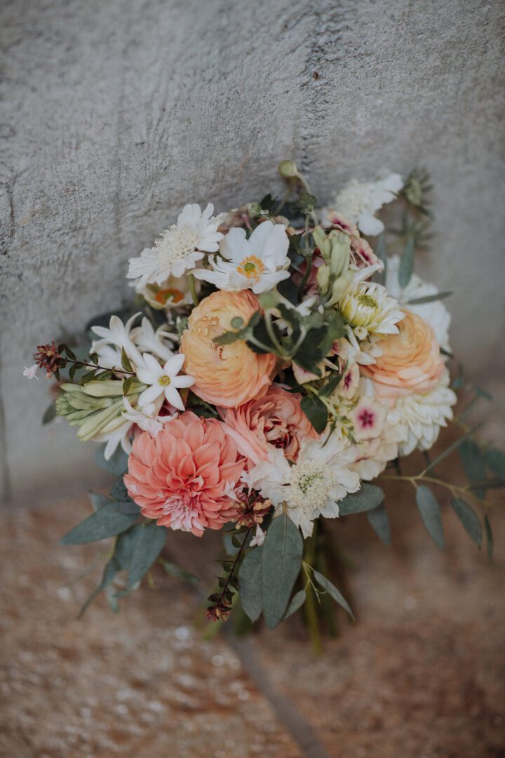 A bouquet of flowers sitting on a stone wall.