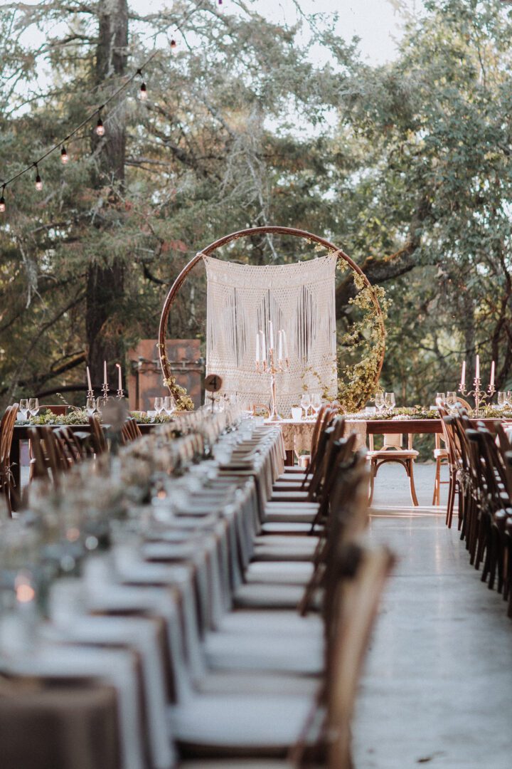 An outdoor wedding reception set up with long tables and chairs.