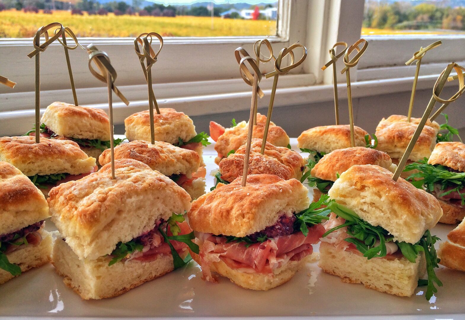 A plate of sandwiches with toothpicks on them.