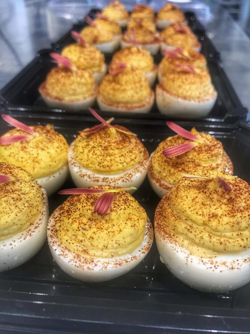 Deviled eggs in a black tray.