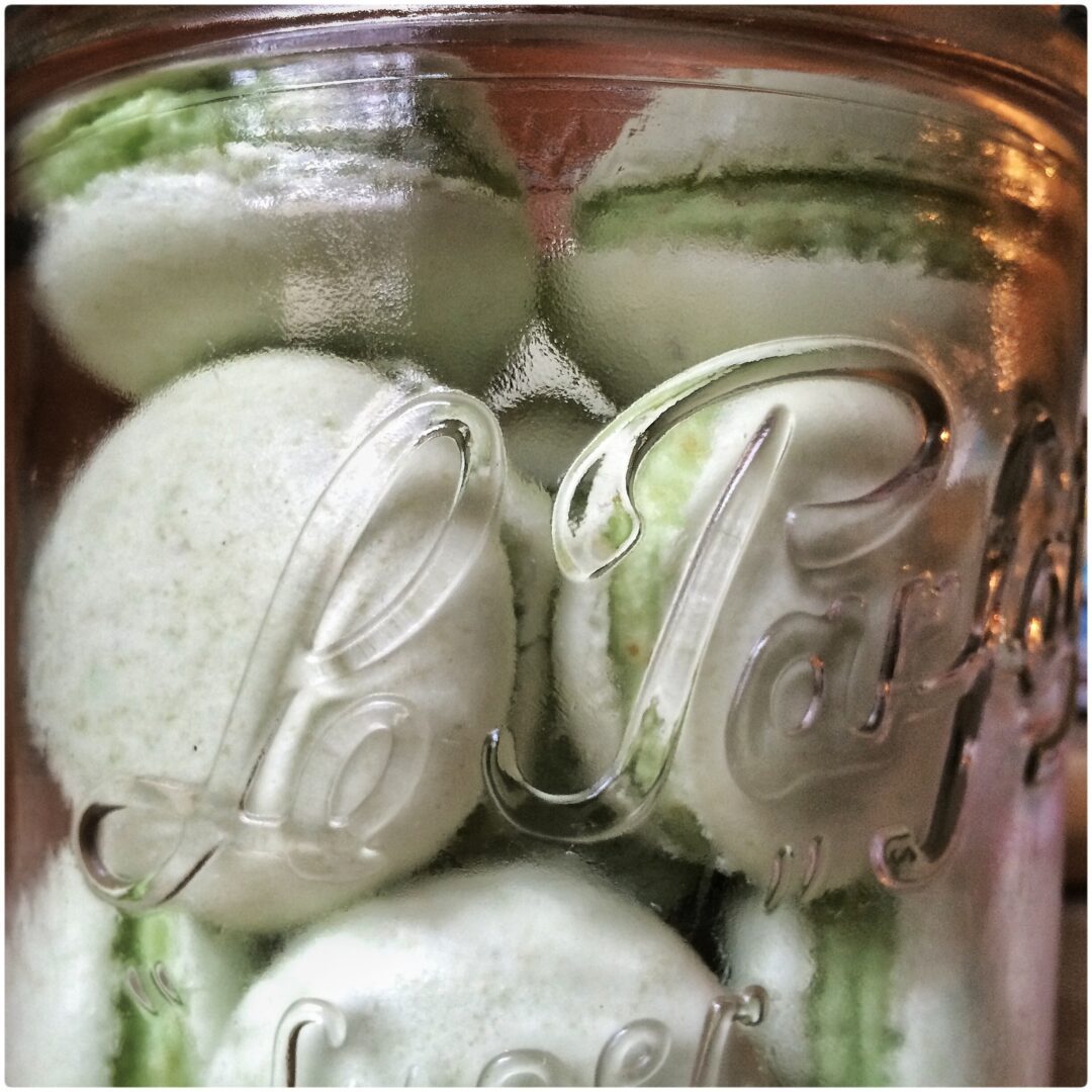 Green macarons in a glass jar.