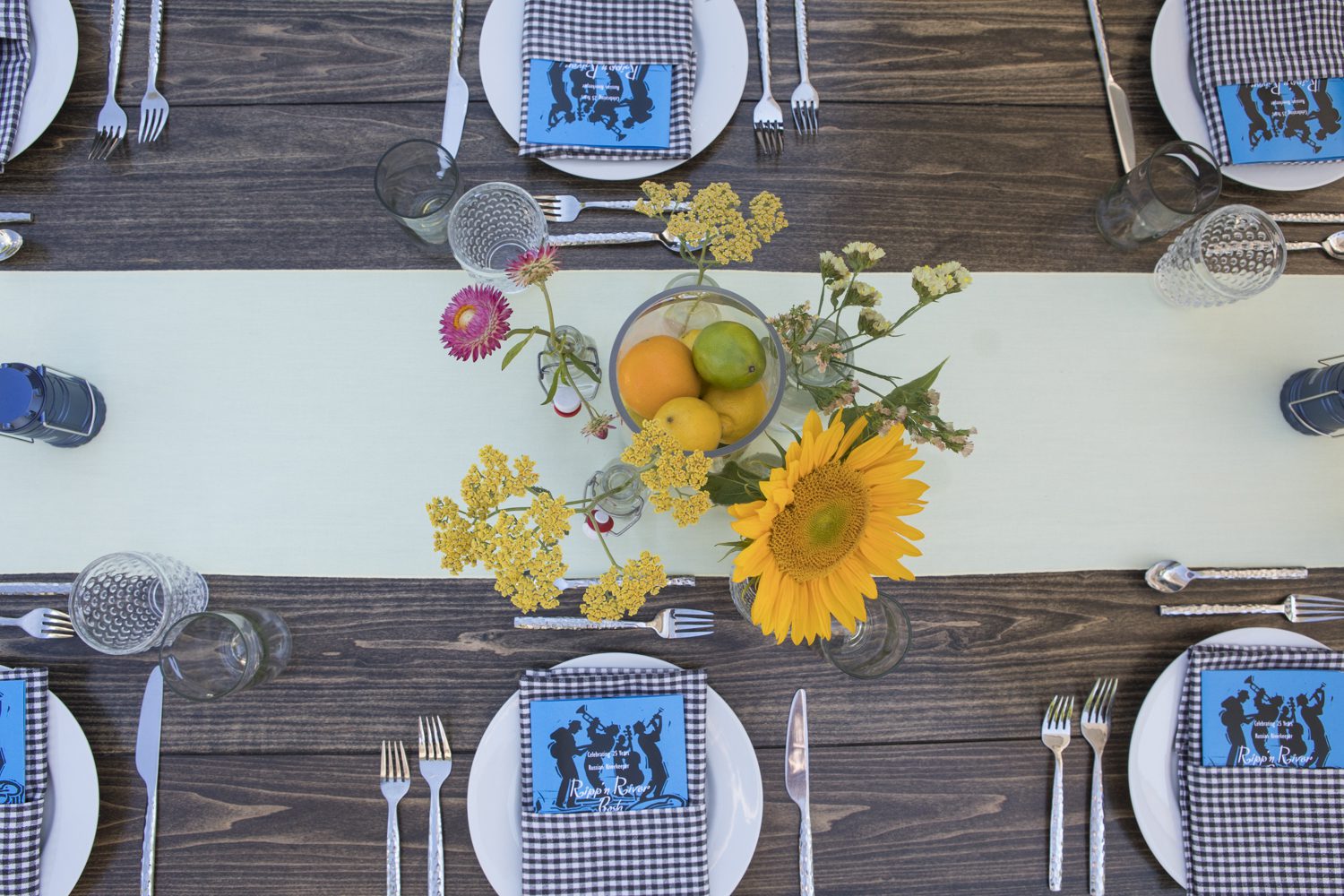 A blue and white table setting with sunflowers.