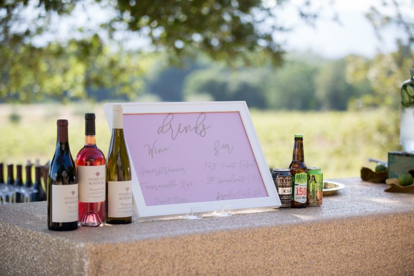 A wine bar with bottles and a sign.