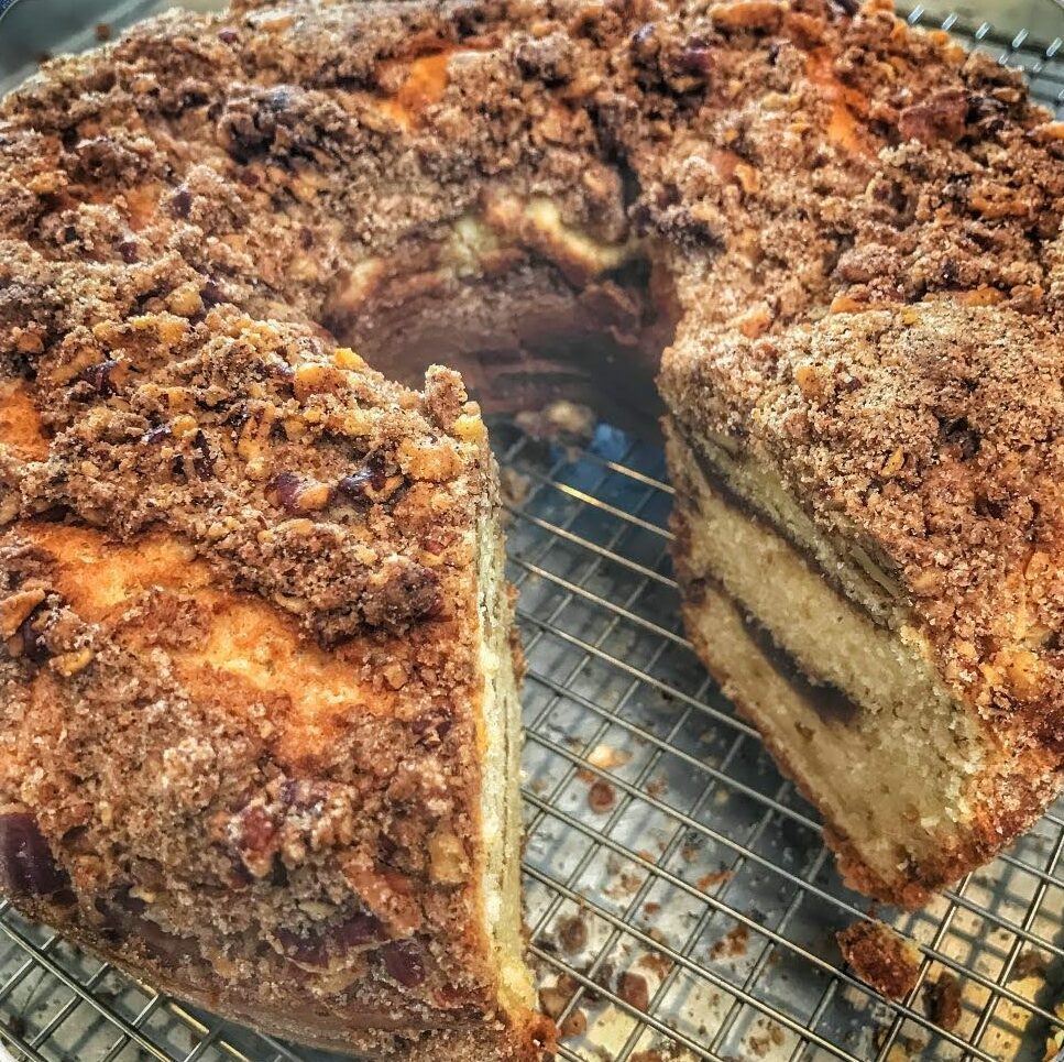 A coffee cake sitting on a cooling rack.