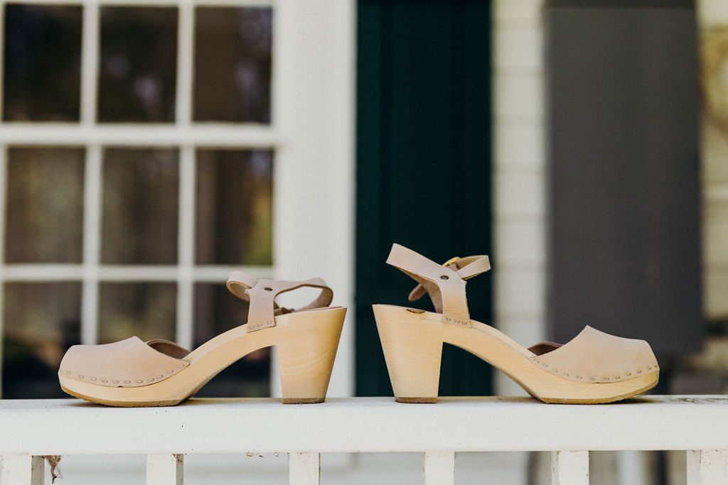 A pair of beige sandals on a porch.