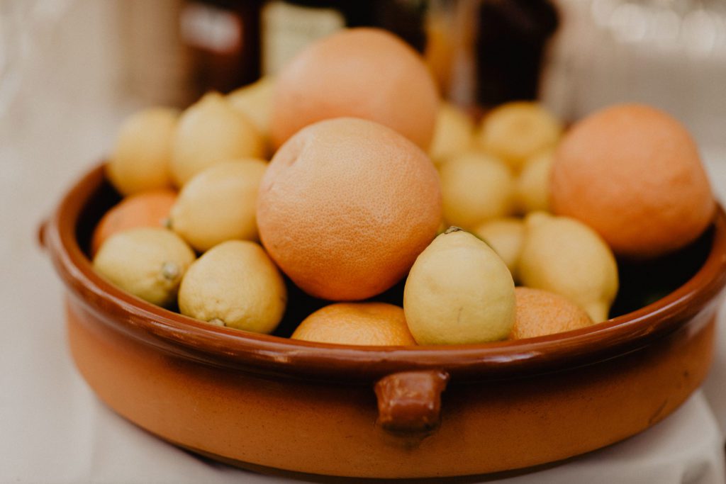 A bowl of oranges and lemons on a table.