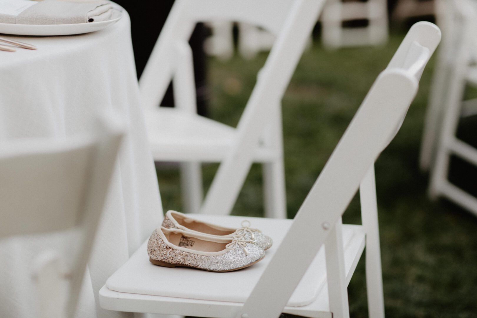 A little girl's shoe sits on a chair at a wedding.