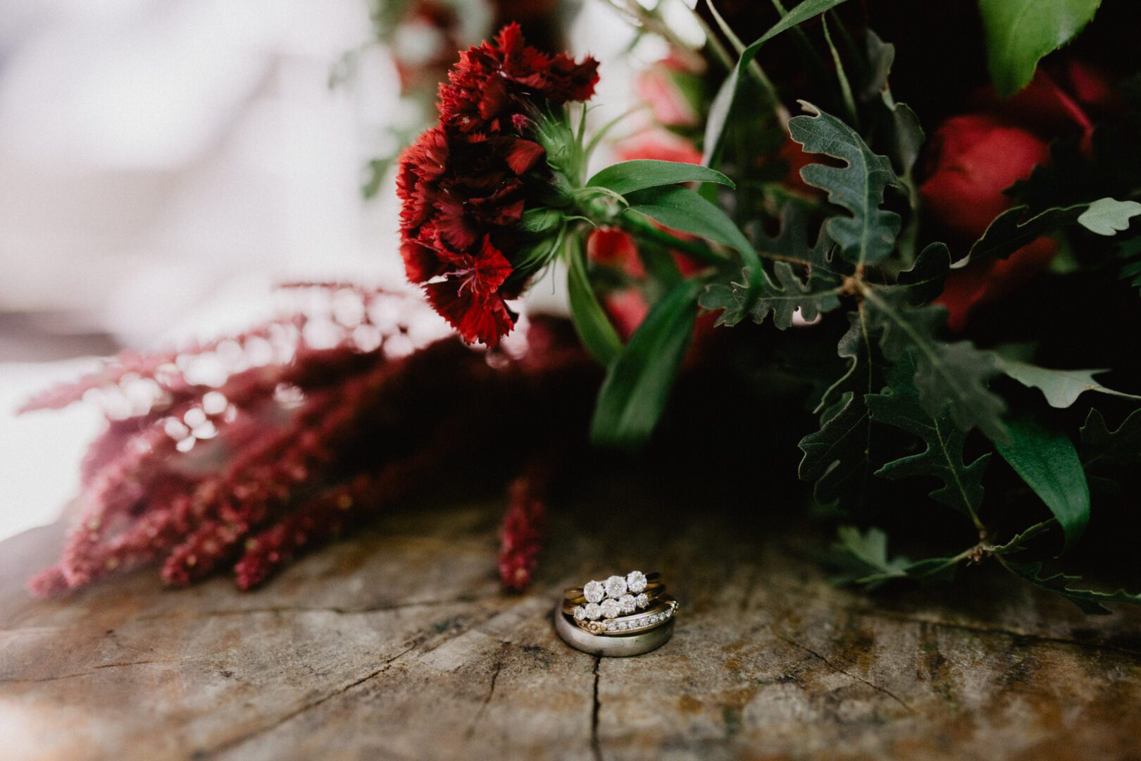 Wedding rings and flowers on a wooden table.