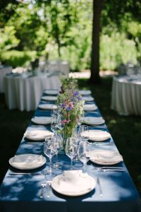 A table set with blue linens and flowers.