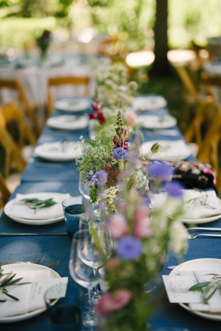 A table set with blue plates and flowers.