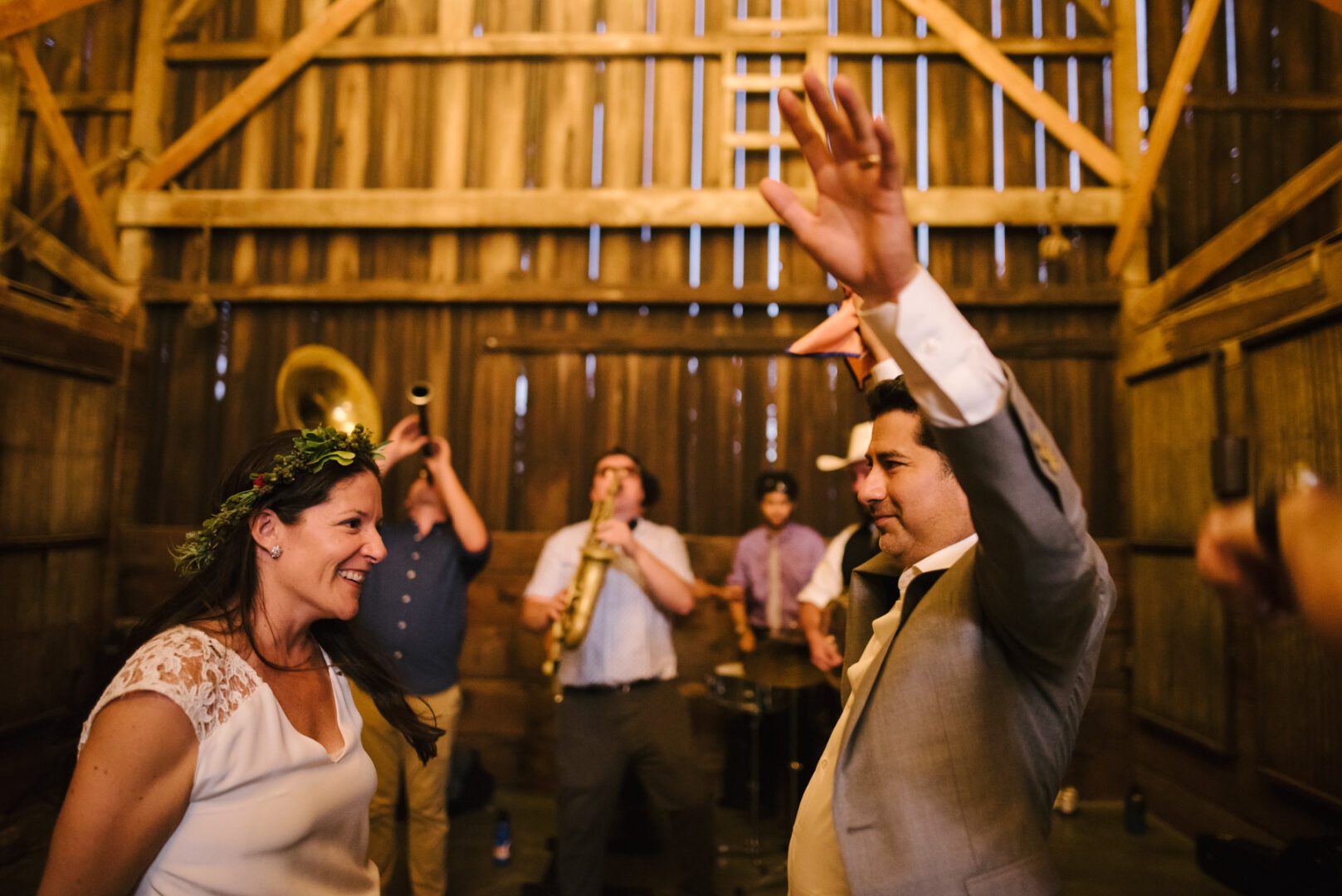 A bride and groom dancing in a barn.