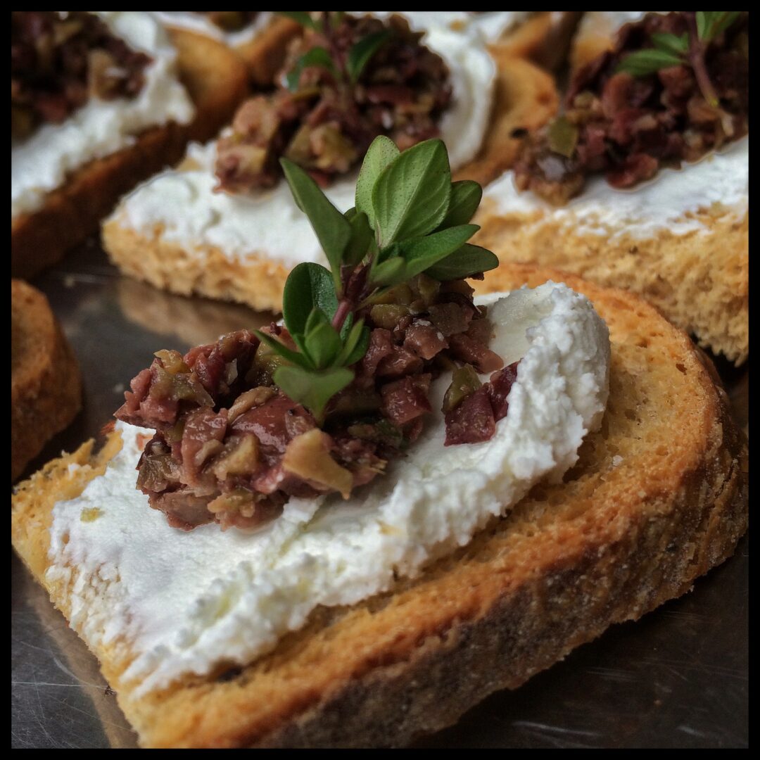 Pug's Leap Chèvre Crostini Adorned with Mixed Olive Tapenade and Serpolet Thyme