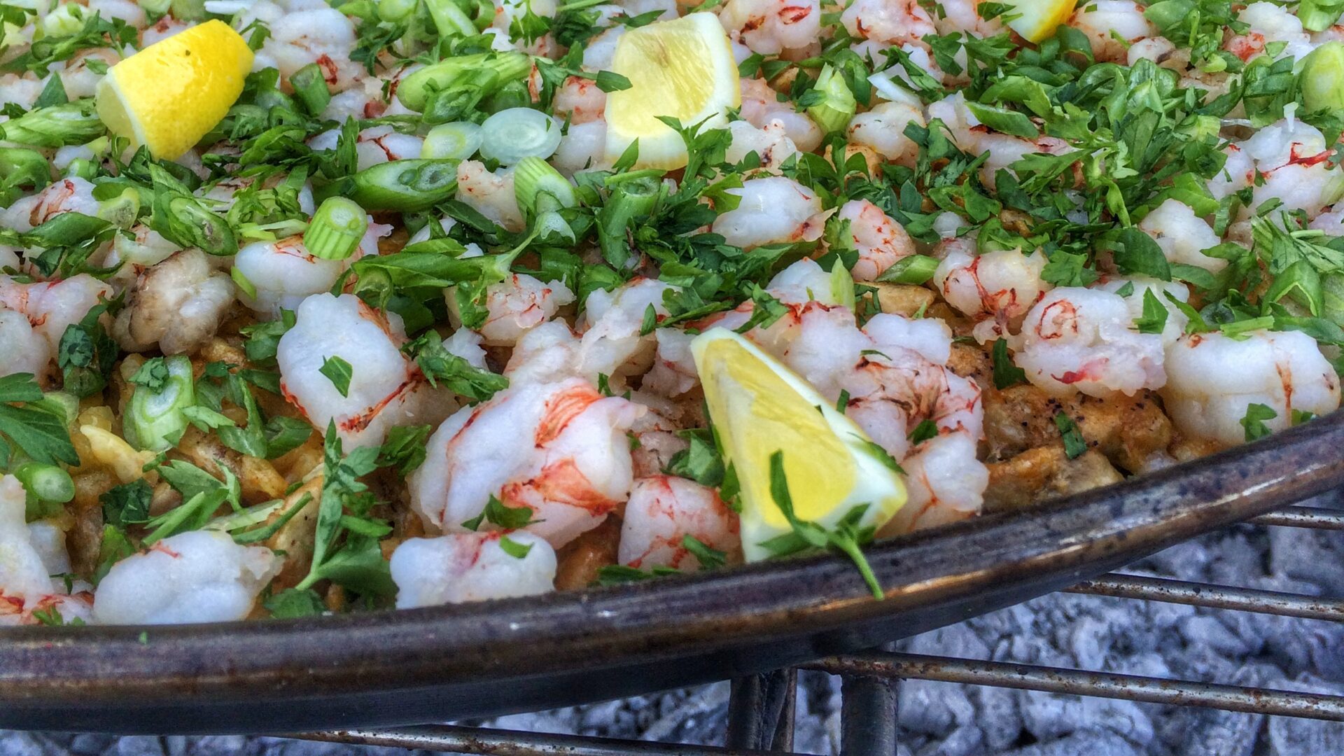 A pan full of shrimp and vegetables on a grill.