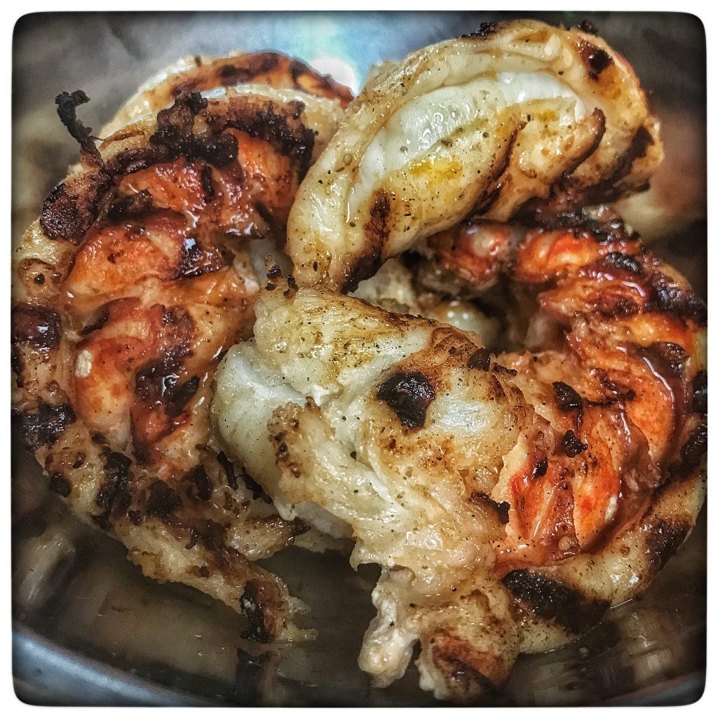 Grilled shrimp in a metal bowl.