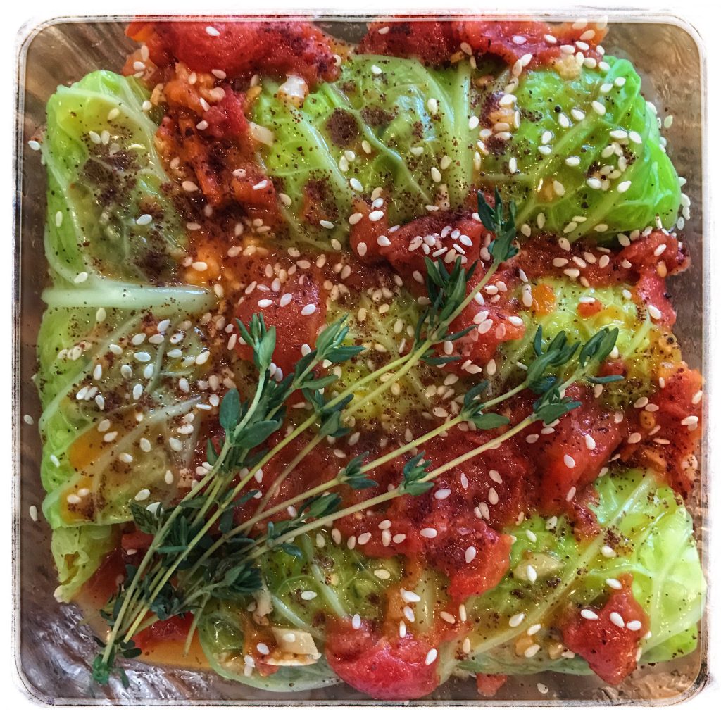 Cabbage rolls with tomatoes and sprigs of thyme.