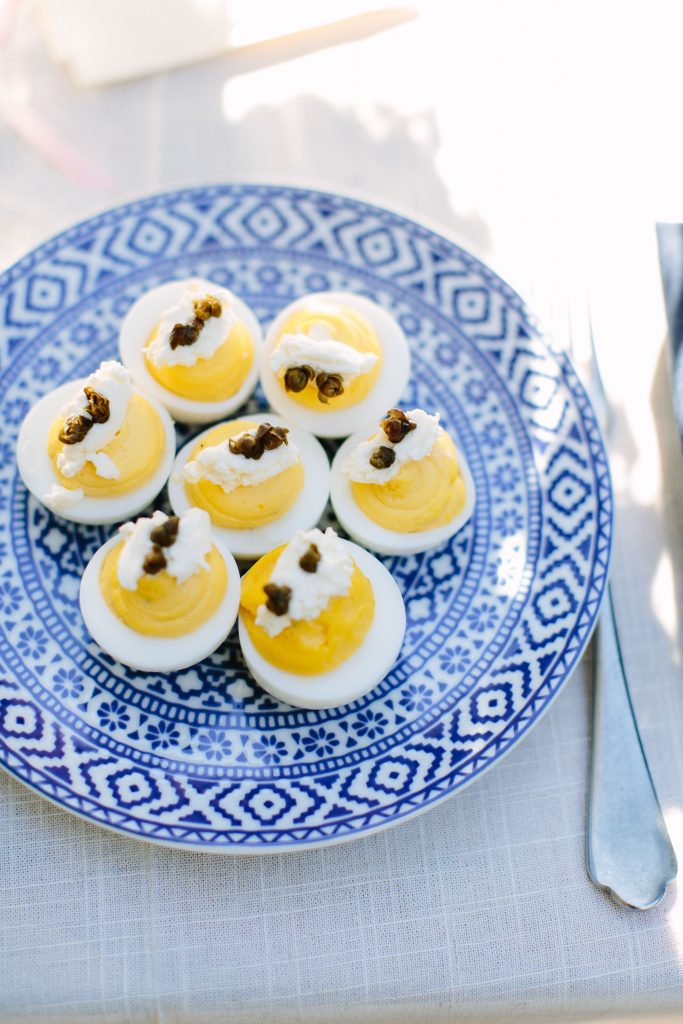 Deviled eggs on a blue and white plate.