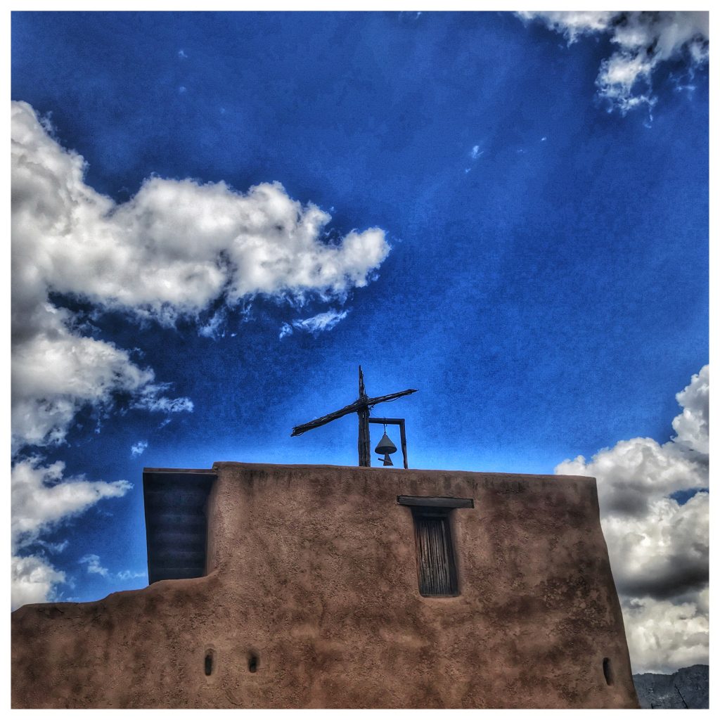 An adobe building with a cross on top.