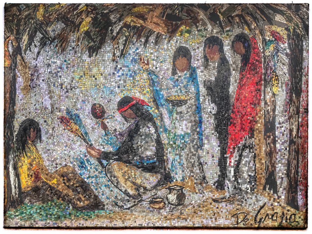 A painting of a group of native people sitting under a hut.