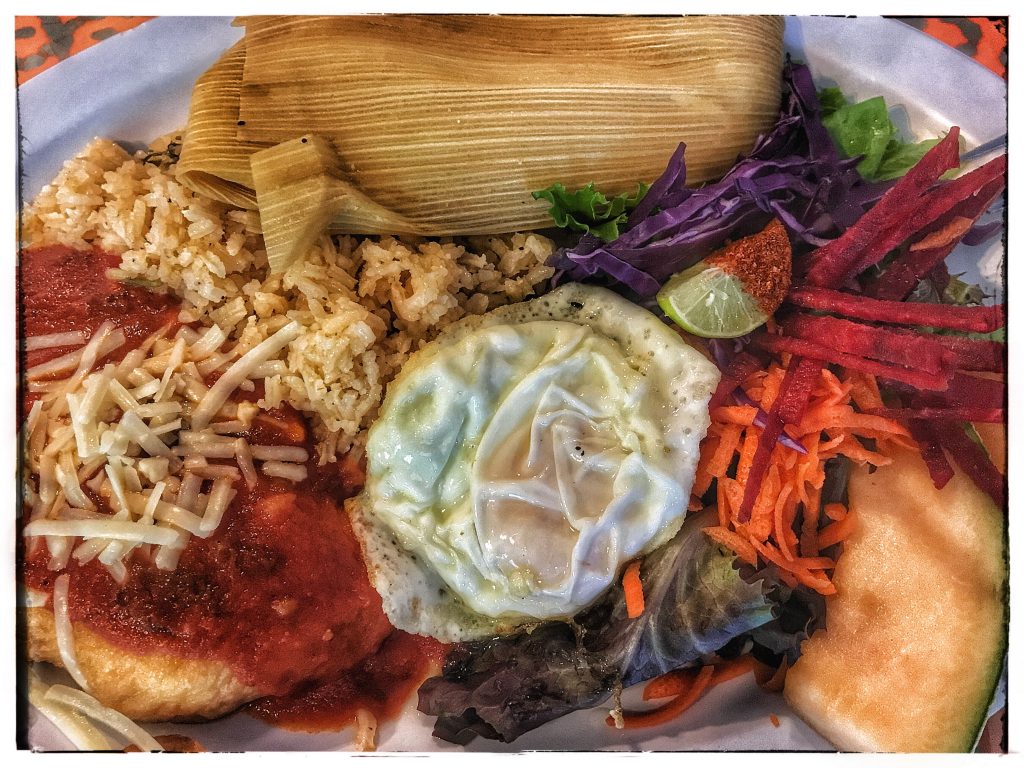A plate of mexican food with rice, vegetables and eggs.