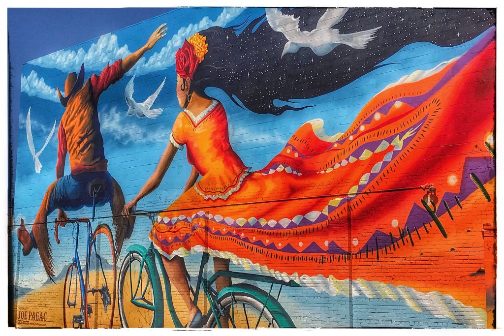 A mural depicting a woman riding a bicycle.