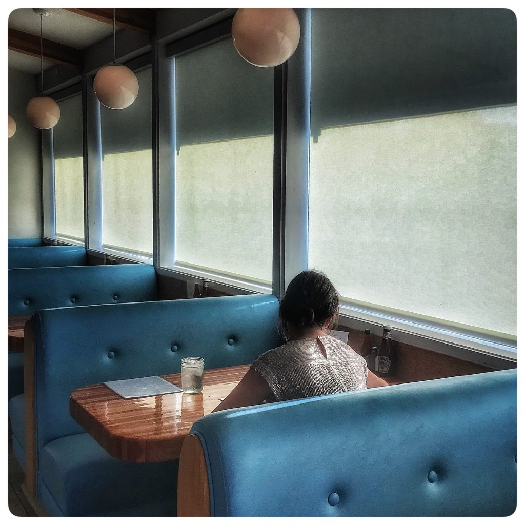 A woman sitting at a table in a restaurant.