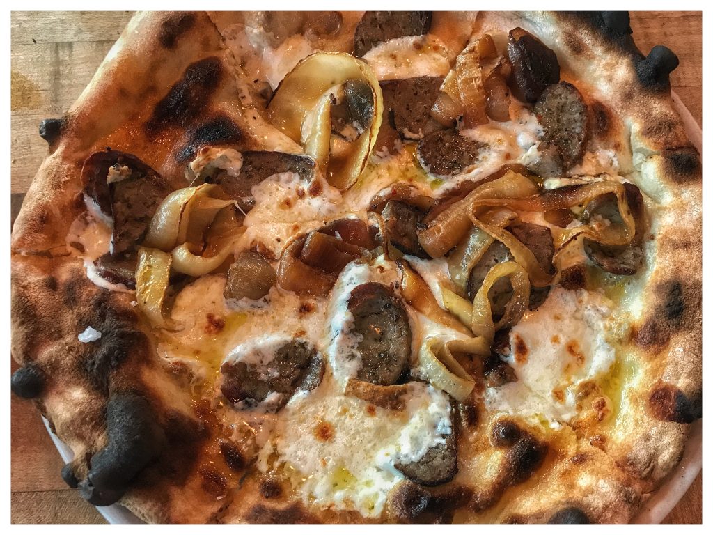 A pizza with mushrooms and onions on top.