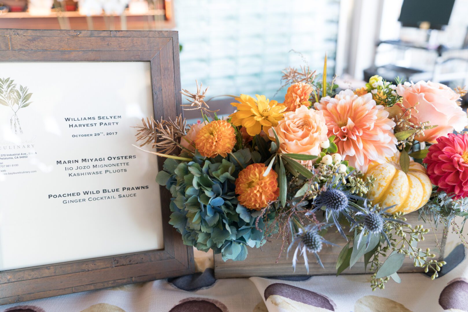 A table with flowers and a framed picture.