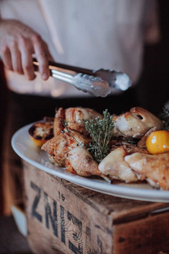 A chef is slicing chicken on a plate.