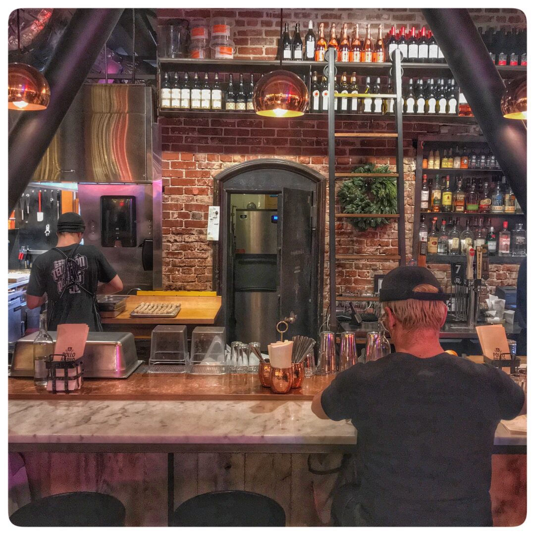 A man is sitting at a bar in a restaurant.